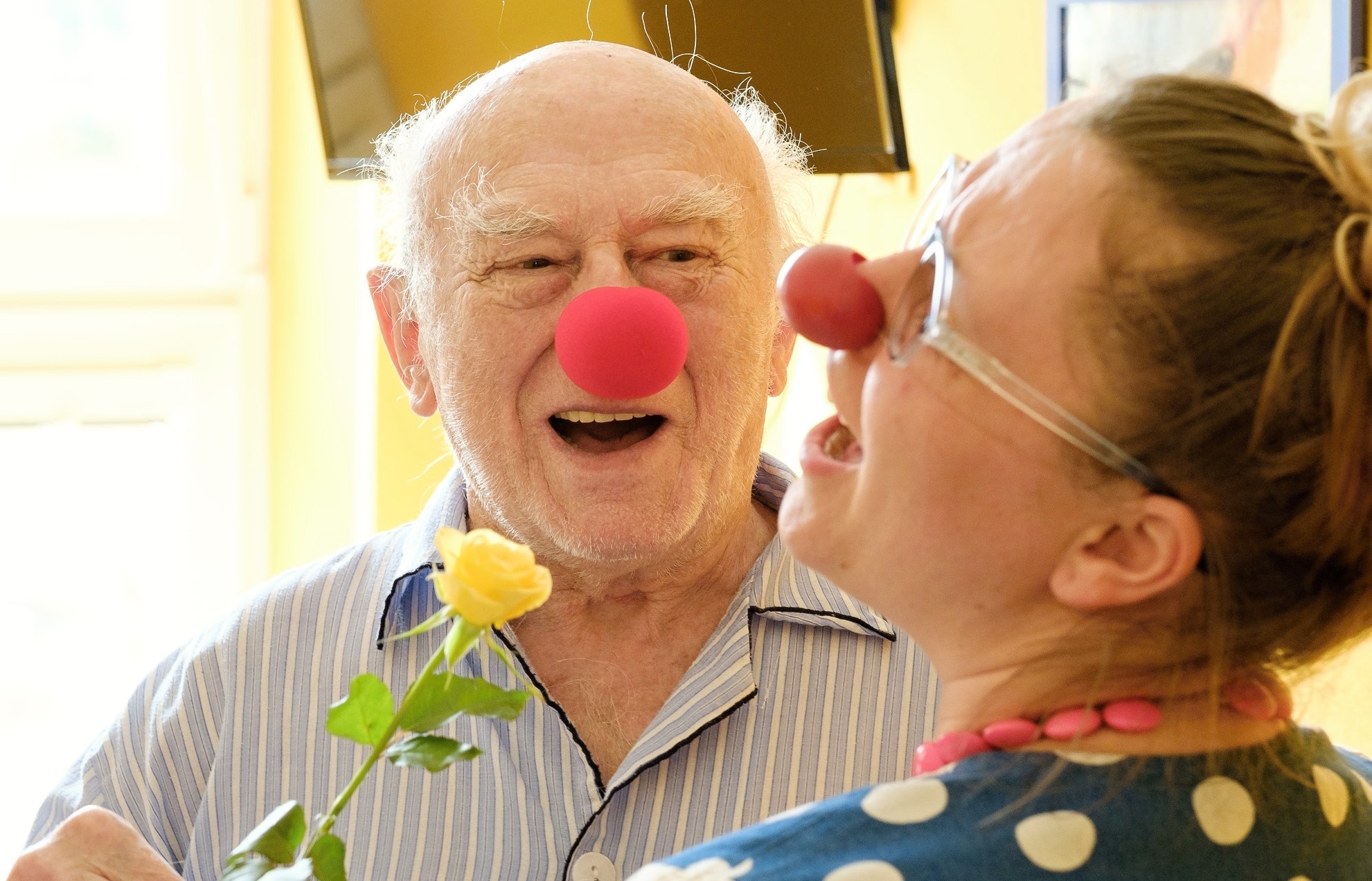 Old man laughing with female clown